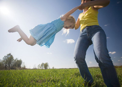 summer fun; mom and daughter outside; mom swinging daughter