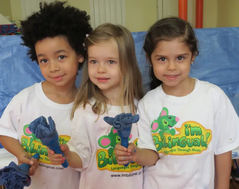 girls holding paint brushes